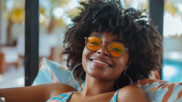 A woman with curly hair wearing sunglasses and a blue shirt