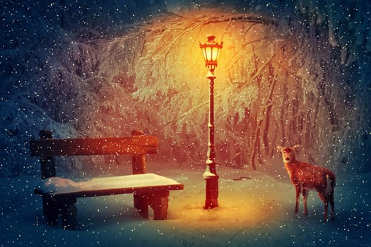 Wooden bench and a glowing lamp in the winter park covered in with snow. Snowing peaceful night scene and a doe looking carefully through the woods.