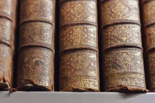 Antique gold-plated books on shelves in library