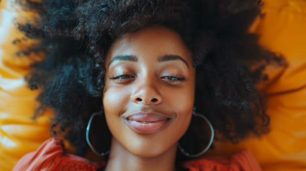 A woman with large hoop earrings laying on a yellow pillow