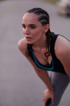 A close-up captures the raw dedication of a female athlete as she rests, sweat glistening, after a rigorous running session, embodying the true spirit of perseverance and commitment to her fitness journey