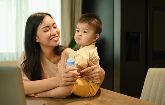 Beautiful young mother spending time with her little son at home. Motherhood and child care concept.