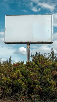 A large white billboard sitting in the middle of a field