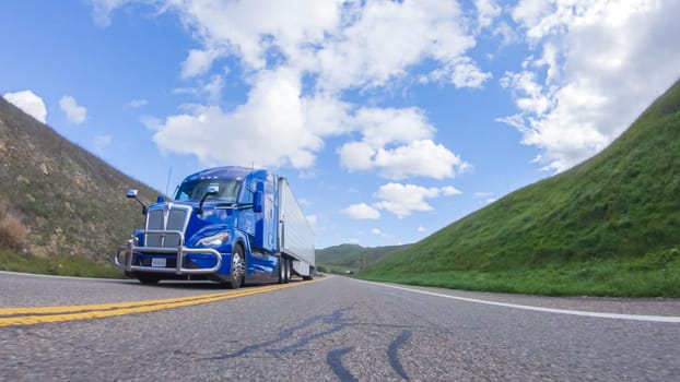 Santa Maria, California, USA-December 6, 2022-On a clear winter day, a car smoothly travels along Highway 101 near Santa Maria, California, under a brilliant blue sky, surrounded by a blend of greenery and golden hues.