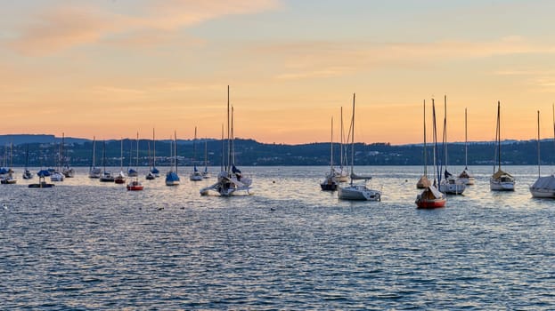 Bodensee Lake Panorama. Evening, twilight, setting sun, picturesque landscape, serene waters, boats and yachts at the dock, beautiful sky with clouds reflecting in the water, riverside at dusk, showcasing the coexistence of technology and production with the environment.