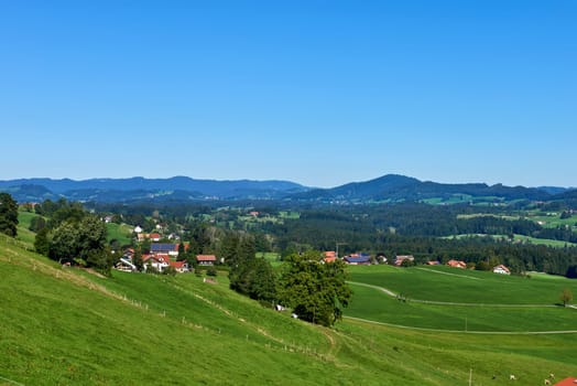 Alpine Foothills Charm: Rural Mountainside Living with Farmer's Homesteads. Mountain Countryside Serenity Captured: Farmer's Dwellings, Pastures, and the Sky Above. Nature's Tapestry Defined: Eco-Friendly Living in the Alpine Highlands. Rural Elegance Revealed: Alpine Homesteads, Pastures, and the Skies of Conservation. Alpine Horizon Explored: Farmers' Dwellings, Green Pastures, and Environmental Harmony