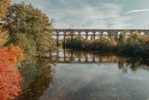 Railway Bridge with river in Bietigheim-Bissingen, Germany. Autumn. Railway viaduct over the Enz River, built in 1853 by Karl von Etzel on a sunny summer day. Bietigheim-Bissingen, Germany. Old viaduct in Bietigheim reflected in the river. Baden-Wurttemberg, Germany. Train passing a train bridge on a cloudy day in Germany