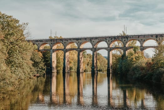 Railway Bridge with river in Bietigheim-Bissingen, Germany. Autumn. Railway viaduct over the Enz River, built in 1853 by Karl von Etzel on a sunny summer day. Bietigheim-Bissingen, Germany. Old viaduct in Bietigheim reflected in the river. Baden-Wurttemberg, Germany. Train passing a train bridge on a cloudy day in Germany