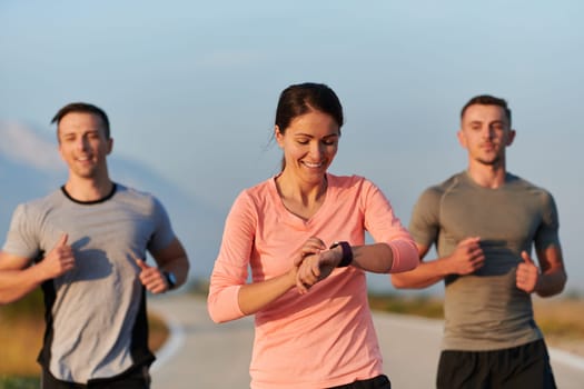 A group of friends, athletes, and joggers embrace the early morning hours as they run through the misty dawn, energized by the rising sun and surrounded by the tranquil beauty of nature.