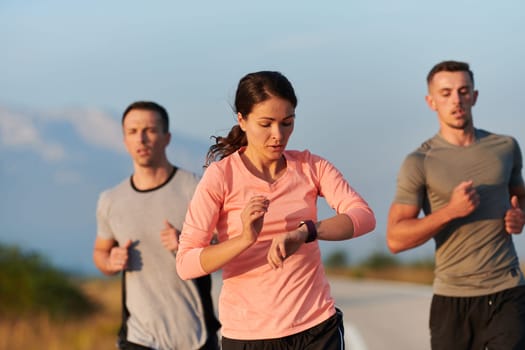 A group of friends, athletes, and joggers embrace the early morning hours as they run through the misty dawn, energized by the rising sun and surrounded by the tranquil beauty of nature.