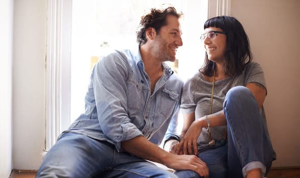 Floor, laughing or happy couple talking in home living room in conversation or speaking together. Man, funny woman or romantic people in apartment or house with love, support or joke humor to relax.