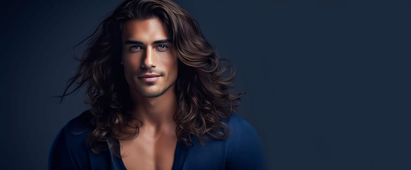 Portrait of an elegant sexy smiling Latino man with perfect skin and long hair, on a dark blue background. Advertising of cosmetic products, spa treatments shampoos and hair care products, dentistry and medicine, perfumes and cosmetology for men