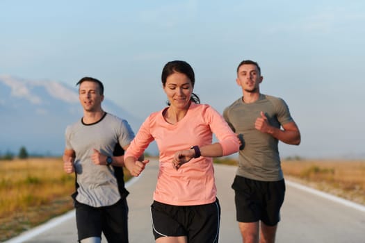 A group of friends, athletes, and joggers embrace the early morning hours as they run through the misty dawn, energized by the rising sun and surrounded by the tranquil beauty of nature.