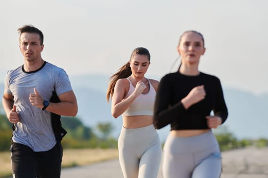 A group of friends maintains a healthy lifestyle by running outdoors on a sunny day, bonding over fitness and enjoying the energizing effects of exercise and nature.