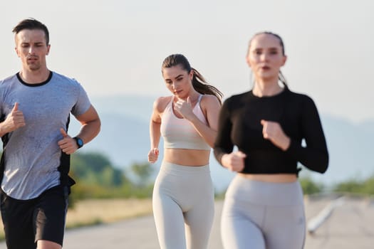 A group of friends maintains a healthy lifestyle by running outdoors on a sunny day, bonding over fitness and enjoying the energizing effects of exercise and nature.