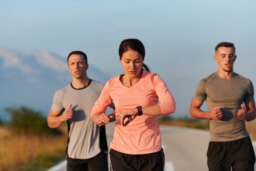 A group of friends, athletes, and joggers embrace the early morning hours as they run through the misty dawn, energized by the rising sun and surrounded by the tranquil beauty of nature.