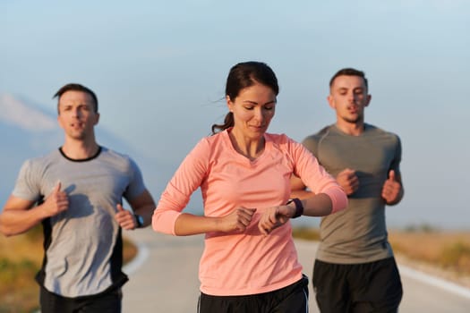 A group of friends, athletes, and joggers embrace the early morning hours as they run through the misty dawn, energized by the rising sun and surrounded by the tranquil beauty of nature.