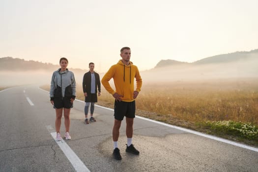 A group of friends, athletes, and joggers embrace the early morning hours as they run through the misty dawn, energized by the rising sun and surrounded by the tranquil beauty of nature.