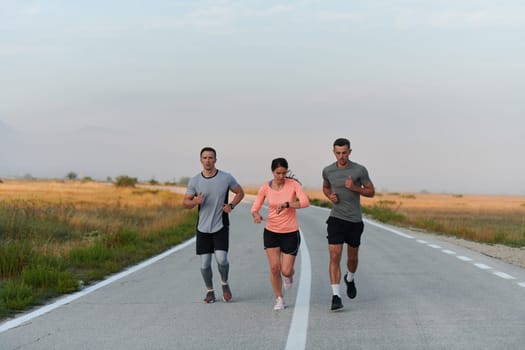 A group of friends, athletes, and joggers embrace the early morning hours as they run through the misty dawn, energized by the rising sun and surrounded by the tranquil beauty of nature.