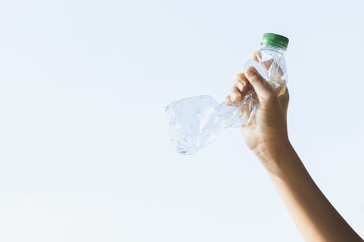 Recyclable plastic bottle held in hand up on sky background. Hand holding plastic waste for recycle reduce and reuse concept to promote clean environment with effective recycling management. Gyre