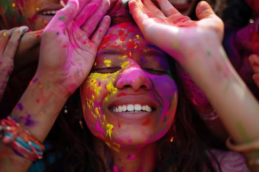 A young girl's face lights up with joy, smeared with vibrant colors during the Holi festival. This moment of pure happiness and cultural tradition shines through