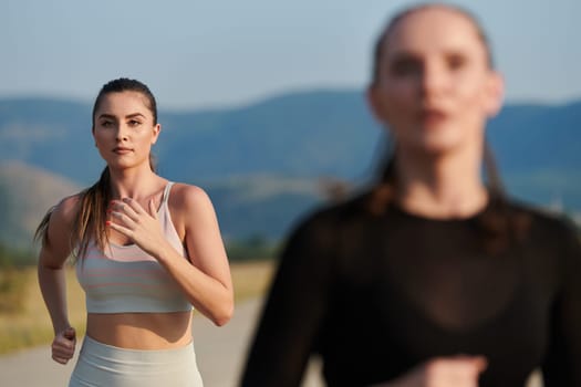 An athletic woman finds freedom and joy in a healthy lifestyle, running through a beautiful road trail at sunrise.