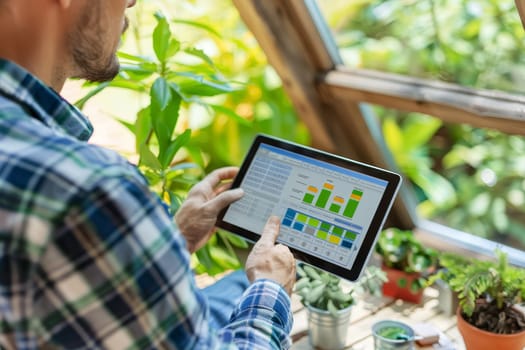 A homeowner stands by the window, tablet in hand, reviewing colorful charts that track energy consumption. Green plants and bright daylight set a scene of eco-conscious living
