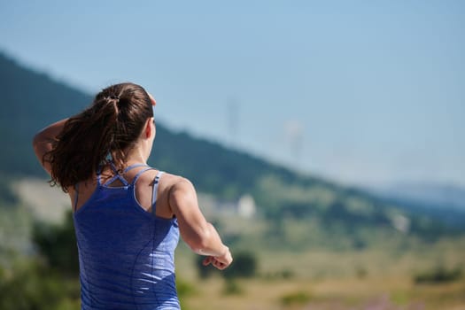 An athletic woman finds freedom and joy in a healthy lifestyle, running through a beautiful road trail at sunrise.