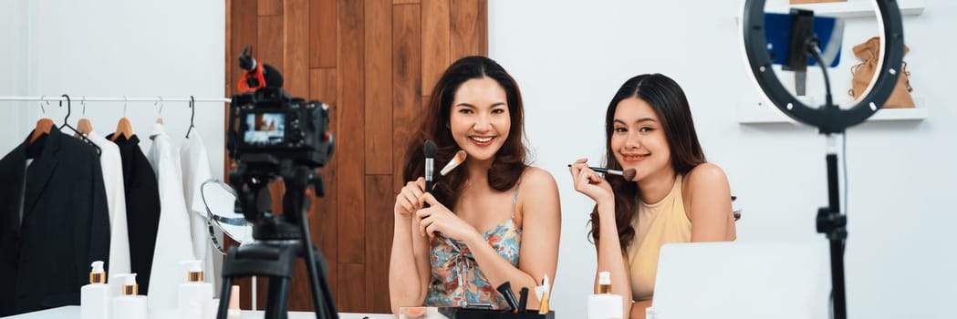 Asian Woman influencer shoot live streaming vlog video review makeup uttermost social media or blog. Happy young girl with cosmetics studio lighting for marketing recording session broadcasting online