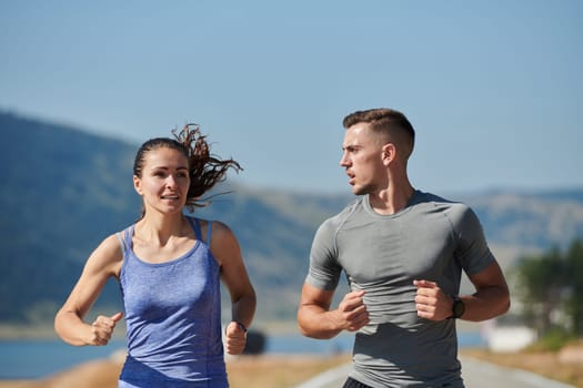 A couple runs through a sun-dappled road, their bodies strong and healthy, their love for each other and the outdoors evident in every stride.