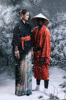 Snow, forest and fashion with Japanese, couple and traditional clothes with season and confidence. People, outdoor and black man with woman and elegant outfit with winter weather and proud with model.