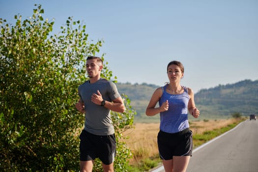 A couple runs through a sun-dappled road, their bodies strong and healthy, their love for each other and the outdoors evident in every stride.