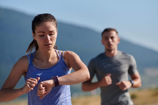 A couple runs through a sun-dappled road, their bodies strong and healthy, their love for each other and the outdoors evident in every stride.