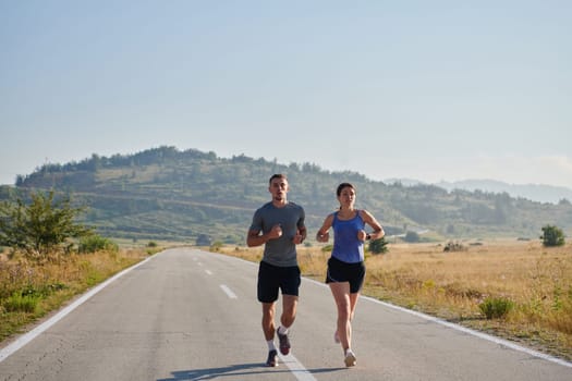 A couple runs through a sun-dappled road, their bodies strong and healthy, their love for each other and the outdoors evident in every stride.