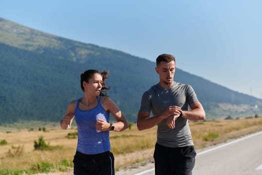 A couple runs through a sun-dappled road, their bodies strong and healthy, their love for each other and the outdoors evident in every stride.