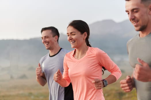 A group of friends, athletes, and joggers embrace the early morning hours as they run through the misty dawn, energized by the rising sun and surrounded by the tranquil beauty of nature.