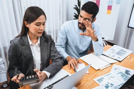 Multiracial analyst team use BI dashboard data to analyze financial report on meeting table. Group of diverse business people utilize data analysis by FIntech for business marketing decision. Concord