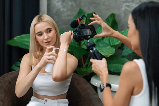 Two beautiful content creator making natural beauty and cosmetic tutorial on green plant garden video. Beauty blogger showing how to beauty care to social medial audience using selfie stick . Blithe