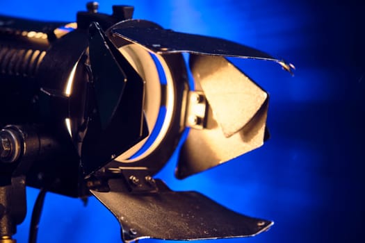 Close-up of a professional lighting fixture on a set or photographic studio. Concept of shooting a movie. color