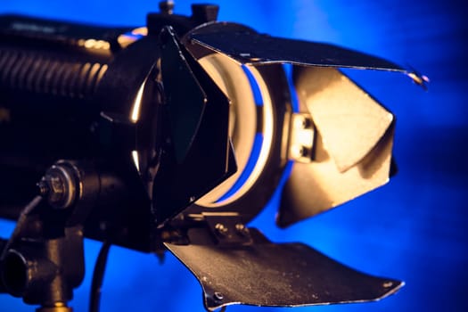 Close-up of a professional lighting fixture on a set or photographic studio. Concept of shooting a movie. color