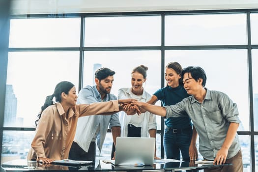 Group of multicultural businesspeople putting hands together at modern office. Happy smart business team working together. Represented unity, working together, partnership, work place. Tracery.