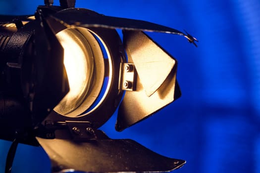 Close-up of a professional lighting fixture on a set or photographic studio. Concept of shooting a movie. color