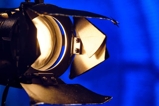 Close-up of a professional lighting fixture on a set or photographic studio. Concept of shooting a movie. color