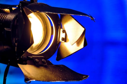 Close-up of a professional lighting fixture on a set or photographic studio. Concept of shooting a movie. color