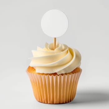 Cupcake with white cream and an inscription plate on a white background.