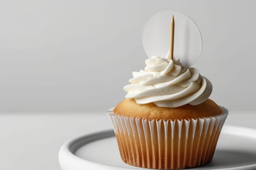 Cupcake with white cream and an inscription plate on a white background.