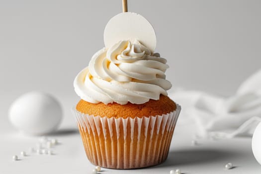 Cupcake with white cream and an inscription plate on a white background.