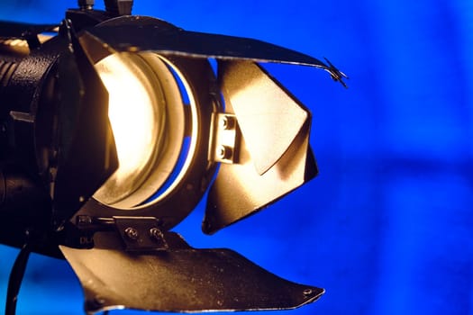 Close-up of a professional lighting fixture on a set or photographic studio. Concept of shooting a movie. color
