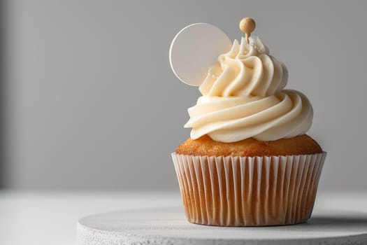 Cupcake with white cream and an inscription plate on a white background.