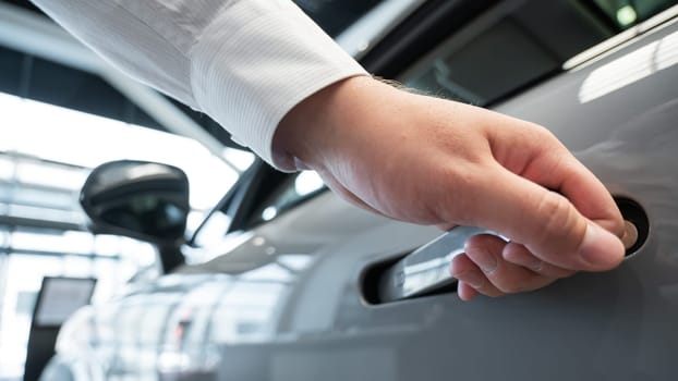A man opens a car door with a fingerprint. Integrated handle
